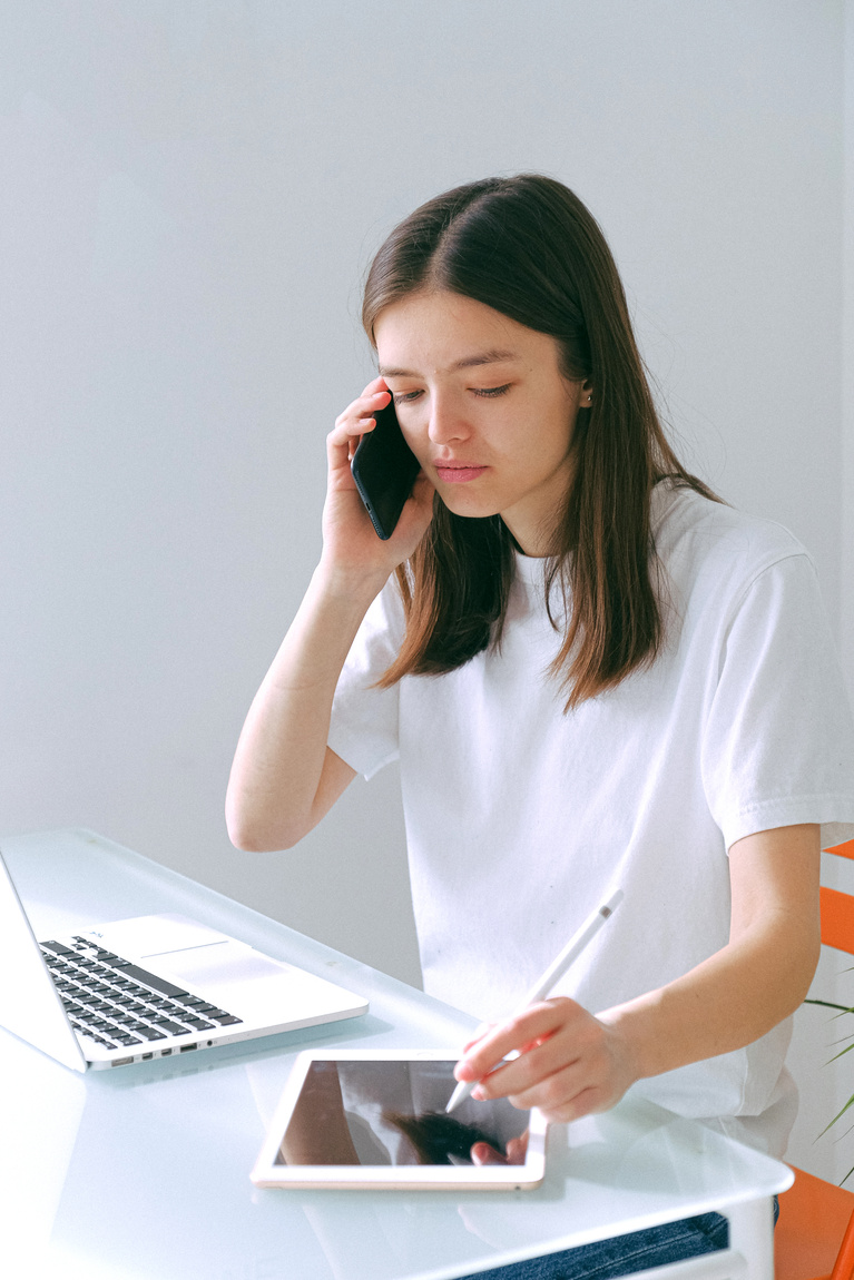Woman in White Crew Neck T-shirt Using Laptop